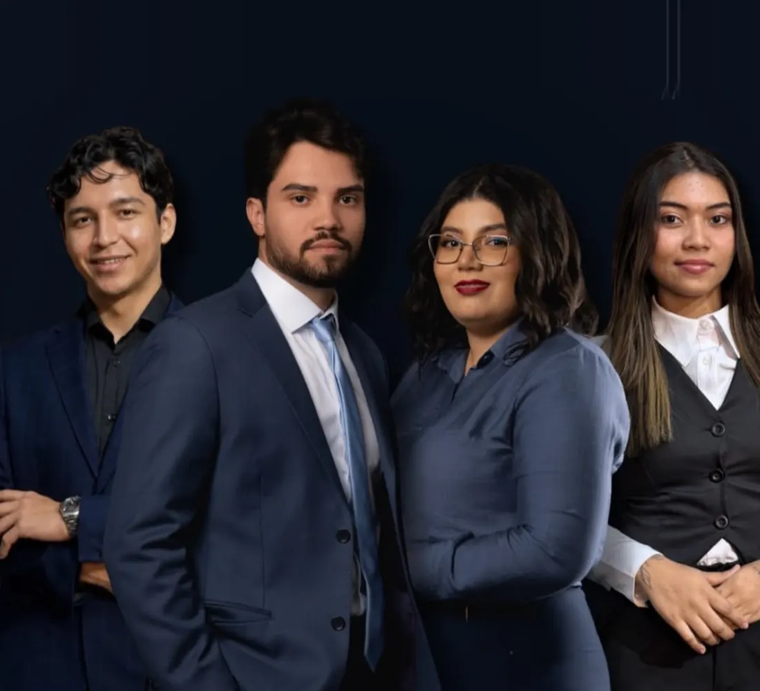 Equipe da Lucas Almeida Advogados reunida: quatro profissionais de azul-marinho, em pé, de braços cruzados